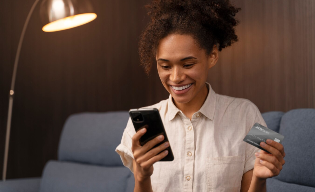 Person happily reviewing a rising credit score on their smartphone