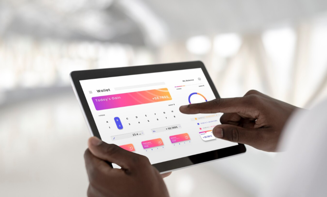 Close-up of a person reviewing a rising credit score on a tablet, with charts in the background.
